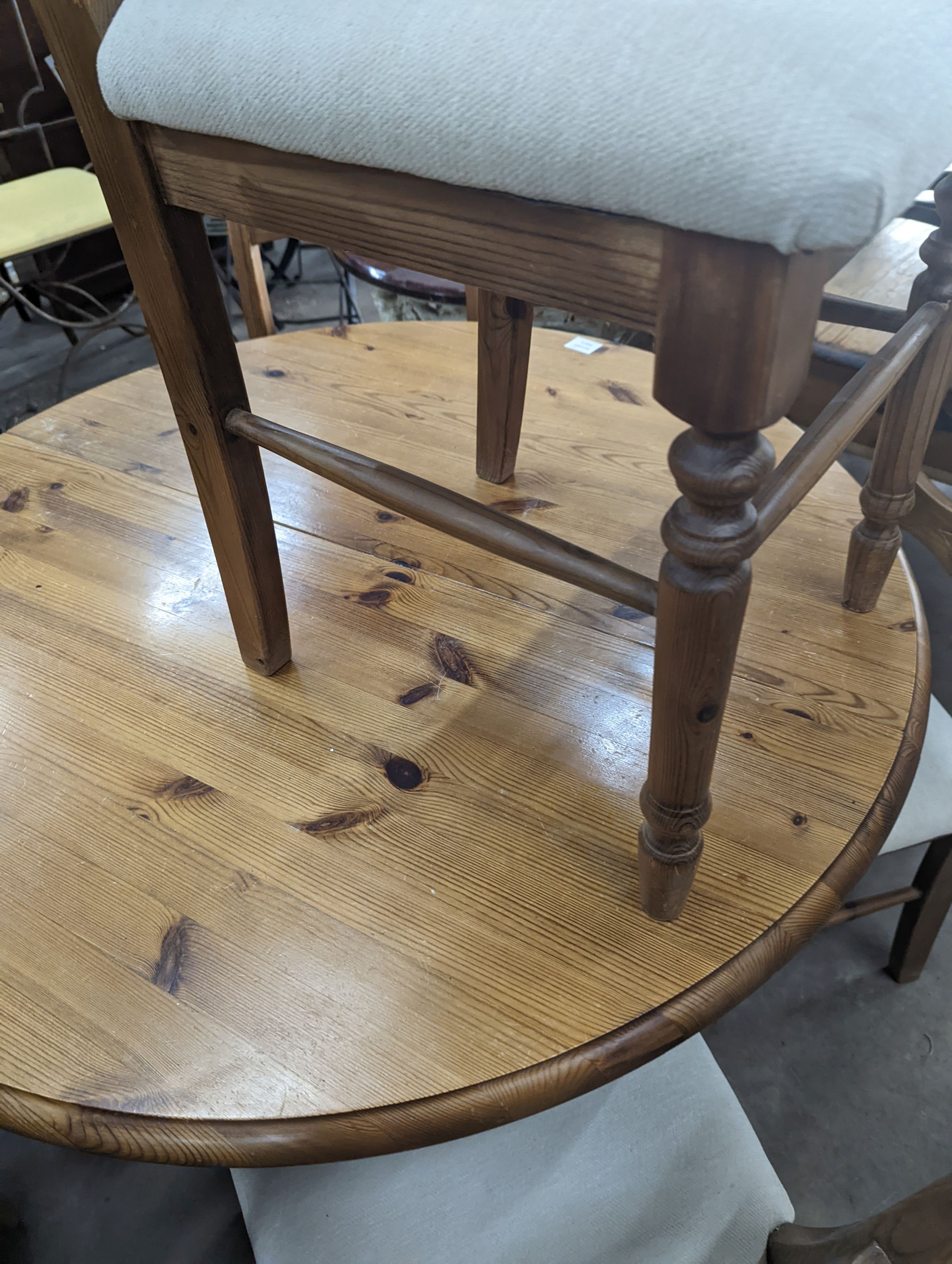 A reproduction circular pine breakfast table, diameter 105cm, height 77cm together with five pine dining chairs
